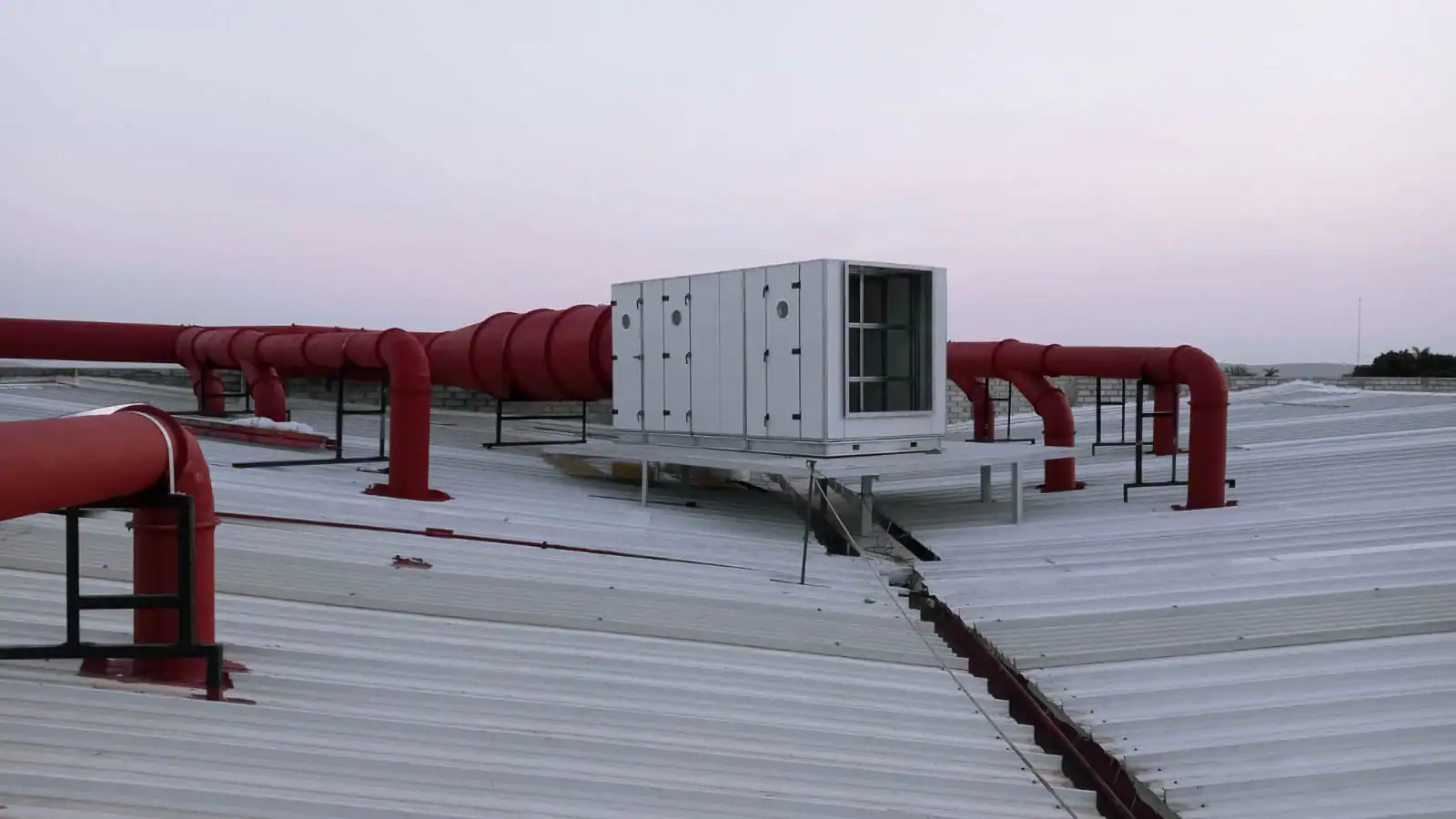 Unidad de manejo de aire en azotea conectada a red de ductos rojos