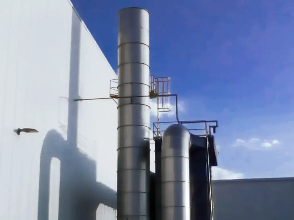 Chimenea industrial con acceso de mantenimiento y ductos verticales