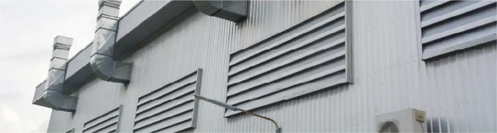 achada de nave industrial con louvers y ductos de extracción — sistema de ventilación industrial para control de aire en México