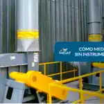 Un técnico utilizando humo o un papel para estimar la medir flujo aire en la boca de un ducto de extracción industrial.