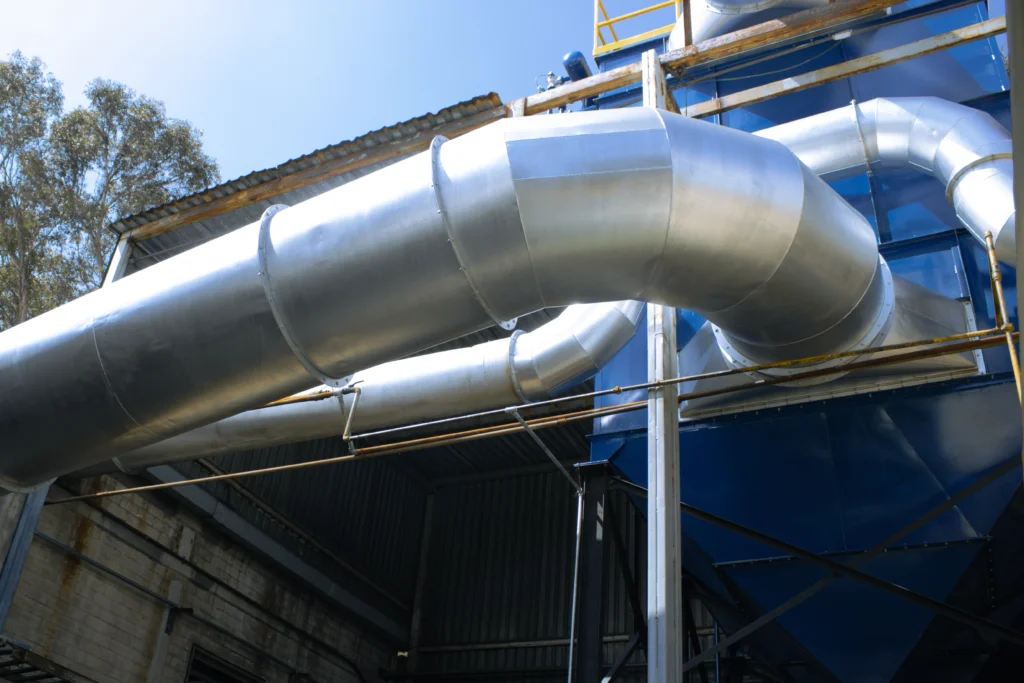 Ductería industrial galvanizada conectada a colector de polvo para extracción y filtración de partículas